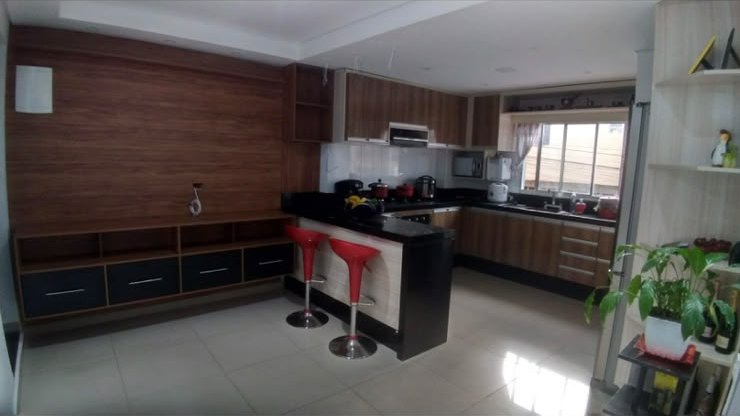 Cozinha com bancada e painel em madeira