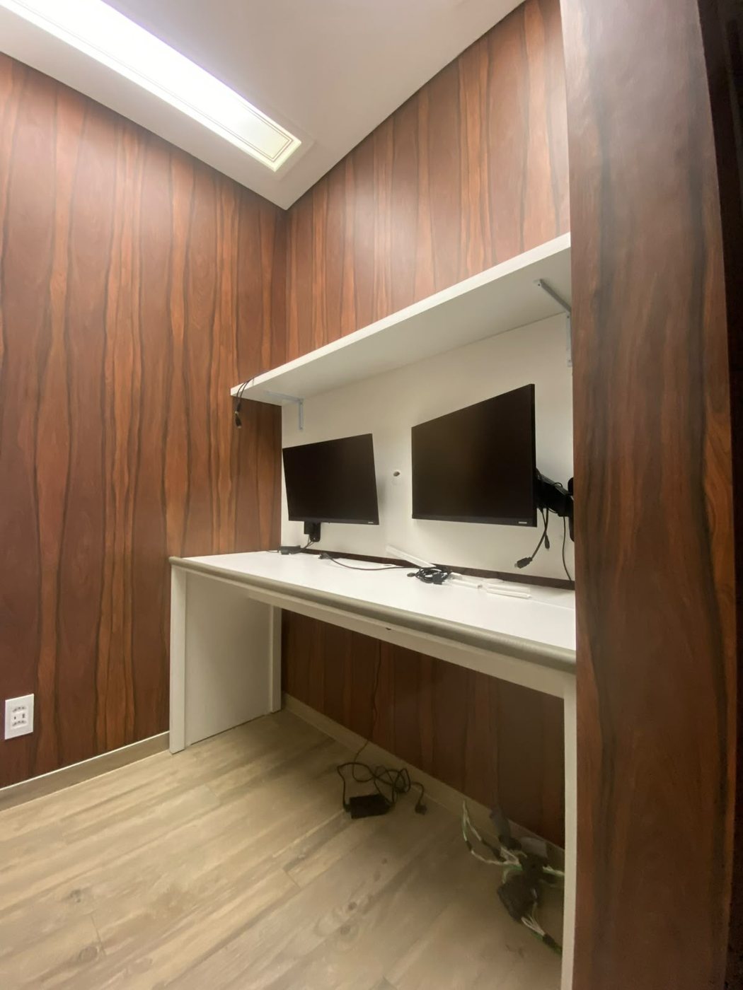 Bancada de home office com painel em madeira