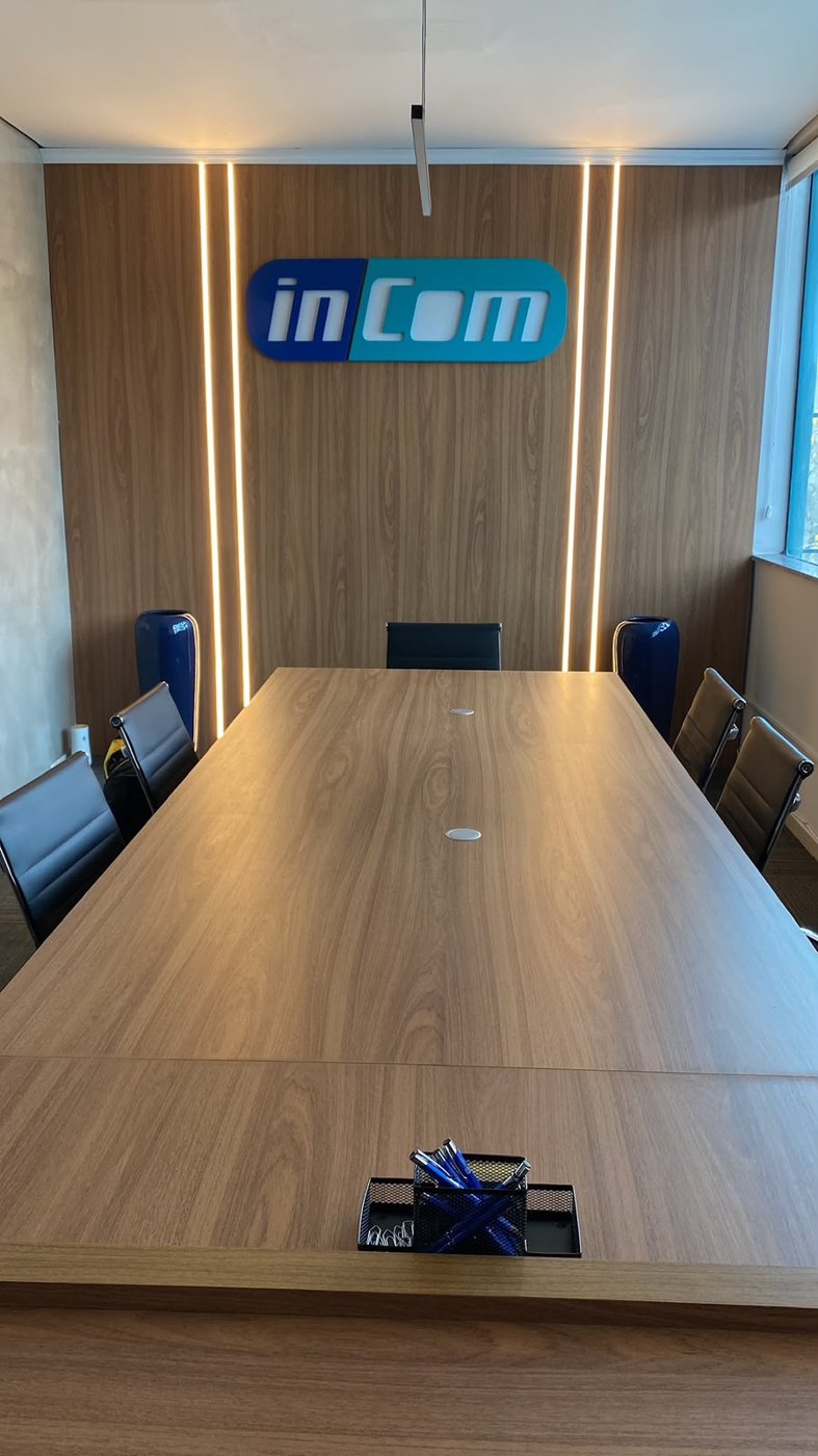 Sala de reunião com mesa e painel em madeira